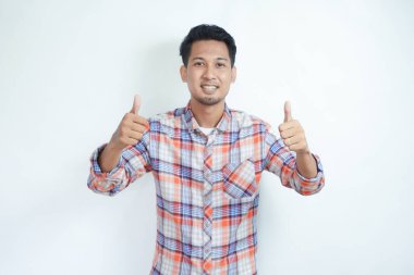 Yetişkin Asyalı adam neşeli bir ifade sergiliyor ve iki parmağını kaldırıyor.