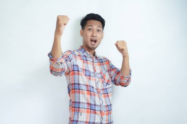 Yetişkin bir Asyalı, kameraya bakıyor ve heyecanlı bir ifade sergiliyor.