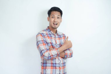 Yetişkin Asyalı adam gülümsüyor ve kameraya başparmağını kaldırıyor.