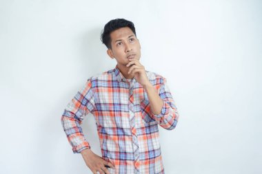 Flanel tişört giyen yetişkin bir Asyalı düşünme hareketi gösteriyor.