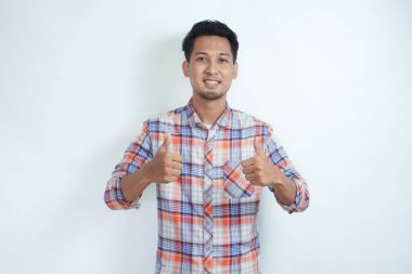 Yetişkin Asyalı adam neşeli bir ifade sergiliyor ve iki parmağını kaldırıyor.
