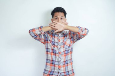 Ağzı örten korkmuş bir adamın beyaz arka planda iki eliyle çekilmiş bir fotoğrafı.