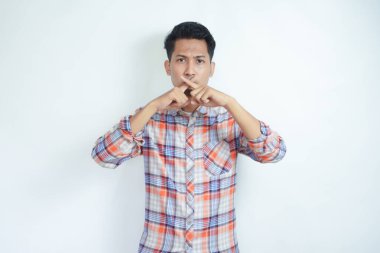 Ağzında X işareti olan kızgın genç bir çocuk.