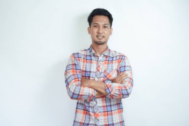 Yetişkin Asyalı adam kollarını kavuşturup mutlu bir ifade sergiliyor.