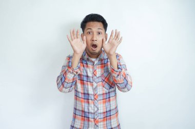 Yetişkin Asyalı adam şok olmuş bir ifadeyle kameraya bakıyor.