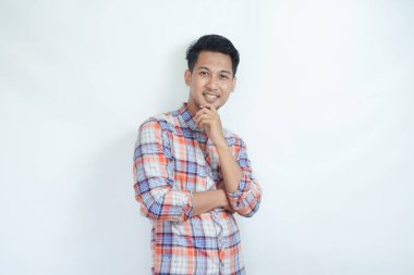 Yetişkin bir Asyalı, kameraya bakarken mutlu bir yüz ifadesi sergiliyor.