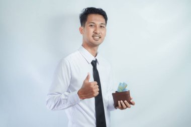Asian businessman smiling and give thumb up while holding money clipart