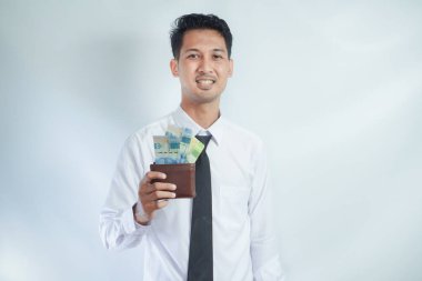 Adult Asian man smiling happy while showing his wallet full of paper money clipart