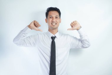 Adult Asian man pointing to plain white shirt with tie that he wearing with happy expression clipart