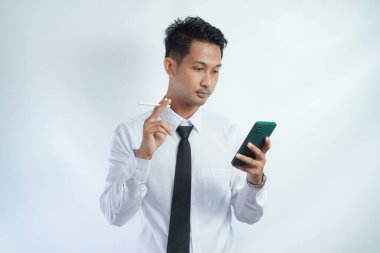 Sigara içen ve akıllı telefon kullanan adam.