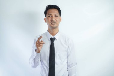 Genç yakışıklı işadamı sigara içiyor.