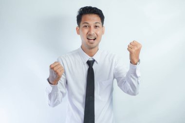 Asyalı genç iş adamı, heyecanlı bir ifade sergiliyor.