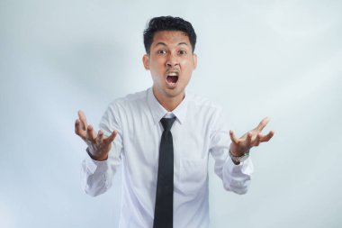 Bilmiyorum, kimin umrunda. Takım elbiseli, omuzlarını silkeleyen kafası karışık Asyalı bir adamın portresi. Beyaz arka planda izole edilmiş kapalı stüdyo çekimi