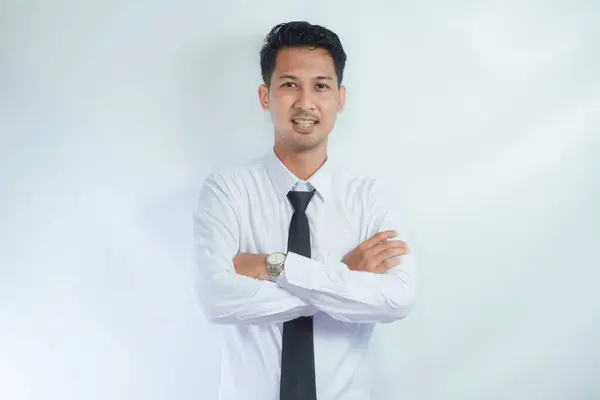 Stock image Young smiling cheerful Asian confident man he wears white shirt look camera hold hands crossed folded isolated on white background studio portrait. Lifestyle concept