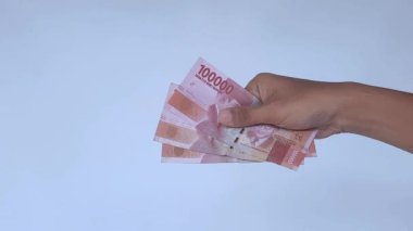 Yaklaş ve para ver. Rupiah 'ın notunu ver.  