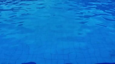 Yüzme havuzu dalgalar yaratır ve bir dalga zeminine karşı akar. Yaz dönemi. Su yüzeyi dokusu. Yukarıdan görüntüle.