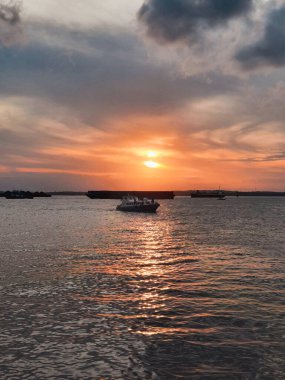 Gün batımında denizin ortasında bir gemi