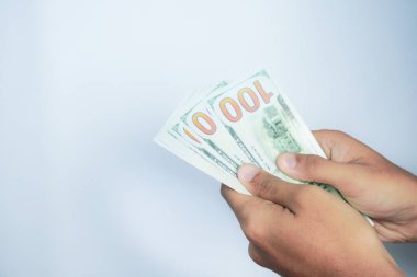 Finans, para ve insan konsepti - beyaz arkaplan üzerinde 100 dolarlık banknotlar tutmak