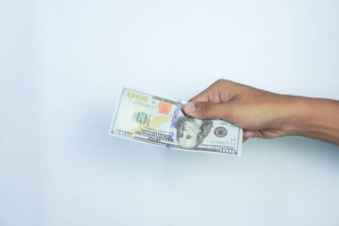 Finans, para ve insan konsepti - beyaz arkaplan üzerinde 100 dolarlık banknotlar tutmak