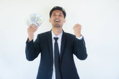 Asyalı genç işadamının elinde para tutması para kazanmaktan mutlu olduğunu gösteriyor.