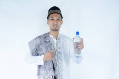 Moslem Asian man smiling happy while showing drinking plastic bottle clipart