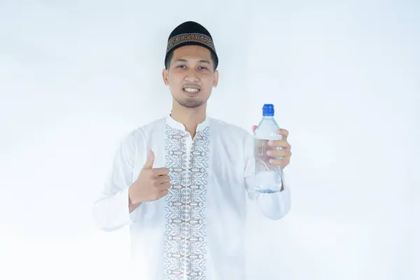 stock image Moslem Asian man smiling at the camera while holding a bottle of drinking water