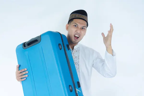 stock image Moslem Asian man showinging disappointed expression while carrying his travelling suitcase