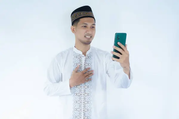 stock image Moslem Asian man smiling happy while video call using his mobile phone