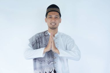 Müslüman Asyalı adam Ramazan kutlamalarında selam vermek için gülümsüyor. Selamlama duruşu yaparken gülen adam