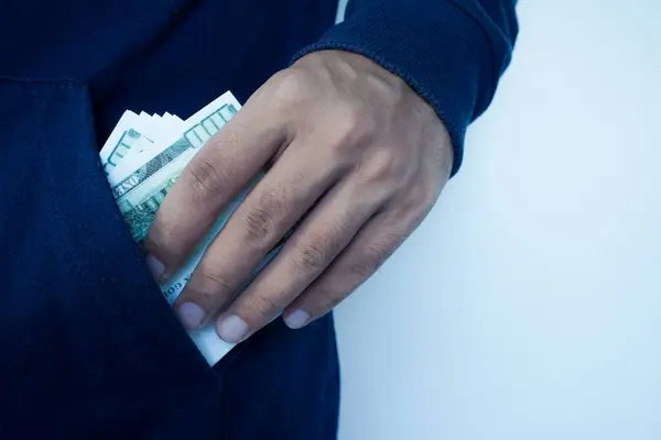 Stock image Man putting a wad of cash into the pocket of jacket