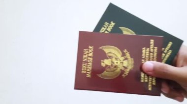 Beyaz arka planda izole edilmiş Endonezya evlilik kitabı. Karım için yeşil evlilik kitabı ve kocam için kırmızı evlilik kitabı.