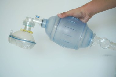 Solunum desteği sağlamak için bir Ambu çantası tutuyor..