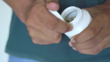 Erkek el plastik şişeden bir avuç içine yeşil ilaç kapsülleri döküyor, antibiyotik haplar, vitaminler, ağrı kesiciler, şeffaf arka planda izole edilmiş. Sağlık ve tedavi kavramı