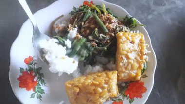 Nasi Pecel, sebze ve fıstık soslu geleneksel Java pilavı, meze ile servis edilir.