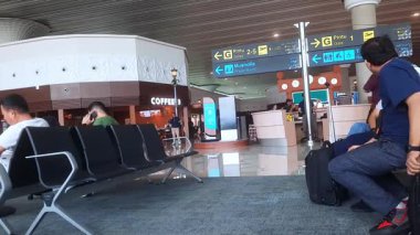 Yogyakarta, 25 Mayıs 2025. İnsanlar bankta oturup havaalanının kalkış alanında bekliyorlar.