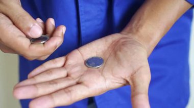 Erkek el ele tutuşup gümüş paraları sayıyor. Yoksulluk kavramı, ödeme, para yok, yoksulluk.