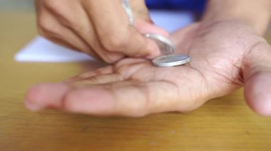 Erkek el ele tutuşup gümüş paraları sayıyor. Yoksulluk kavramı, ödeme, para yok, yoksulluk.