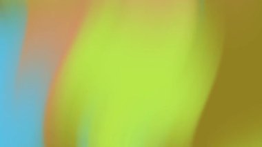 Bulanık mavi turuncu ve açık yeşil renkler soyut arkaplan oluşturur. Renkli, modern estetik tasarım projeleri için uygun.