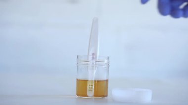 İdrar örneği konseptiyle idrar testi yapan bir tıp bilimcisi.