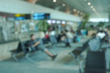 airport waiting area blurred view of passengers and chairs