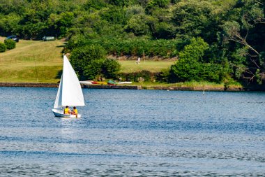 Asturias limanında büyük beyaz kanatları olan bir nehirde yelken açan bir tekne.