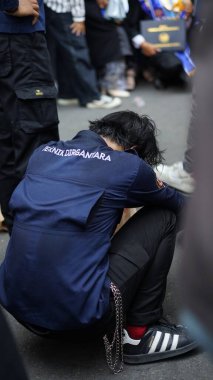 Asyalı adam dua etmek için el ele tutuşuyordu..