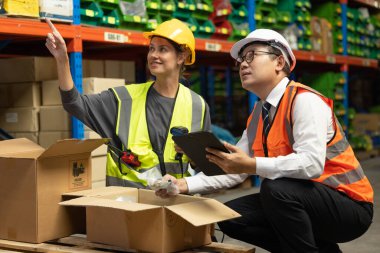 Depo çalışanı etiketi ve el tarayıcısı ile ürünleri etiketleyip siparişleri tamamlıyor. Tüm ürünlerin güvenli ve güvenli bir şekilde paketlendiğini ve doğru yere gönderilmek üzere etiketlendiğini doğrula.