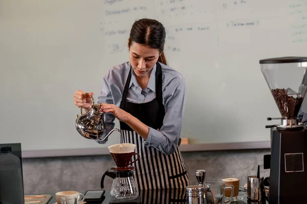 Young adult baristas follow recipes to create artisan and specialty beverages. Making drip coffee with a unique way. Small business owners practice the sense of taste and scent at slow bar coffee.