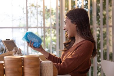Vazo sahipleri çevrimiçi siparişleri işlerler, ürün formu raflarını seçerler, fotoğraf çekerler, paketlerler ve müşterilere gönderim için hazırlanırlar. Teslimat zamanını veriyorum. E-ticaret girişimcilerinin rutin çalışmaları