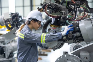 Robot teknisyenleri güvenlik onarımı için tornavida ve kerpetenle bileşenleri sıkılaştırıp gevşetiyorlar. Akım, voltaj, direnç, kapasite, dijital klemp ölçer ile sıcaklık ölçülüyor.