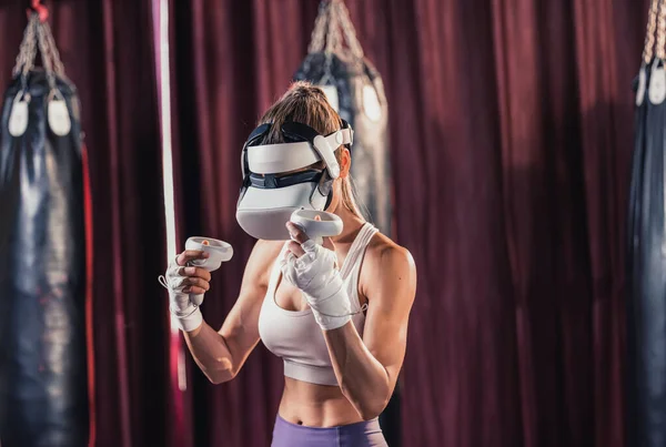 stock image Fitness lovers battle against other gym members by wearing virtual reality goggles during intense boxing exercises. Learning and improving boxing techniques, from simple strikes to complex combos