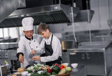 Gençler aşçılık okulundaki uzman şeflerden malzeme hazırlamayı ve çeşitli lezzetli yemekler yapmayı öğreniyorlar. Zevk ve koku duyularını birbirine bağlayan pratik bir aktivite hamburgerleri yapıyor..