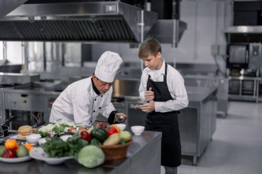 Gençler aşçılık okulundaki uzman şeflerden malzeme hazırlamayı ve çeşitli lezzetli yemekler yapmayı öğreniyorlar. Zevk ve koku duyularını birbirine bağlayan pratik bir aktivite hamburgerleri yapıyor..