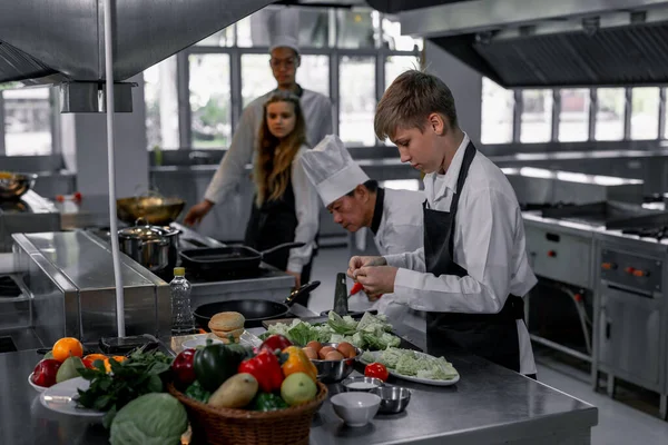 Teenagere Lærer Ekspertkokke Kulinarisk Skole Forberede Ingredienser Skabe Række Velsmagende - Stock-foto